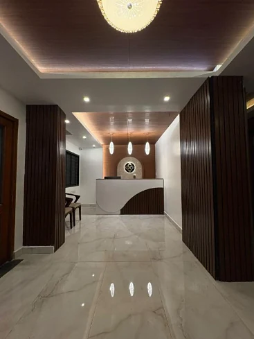 Reception desk with timber slat walls, a lit ceiling and marble floor